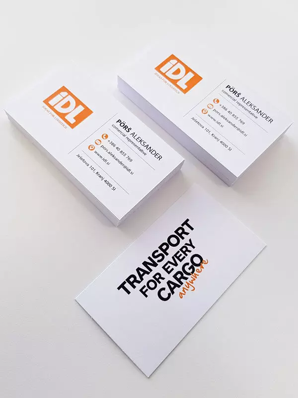 Vizitke podjetja IDL za transportne storitve z oranžnim logotipom in sloganom.