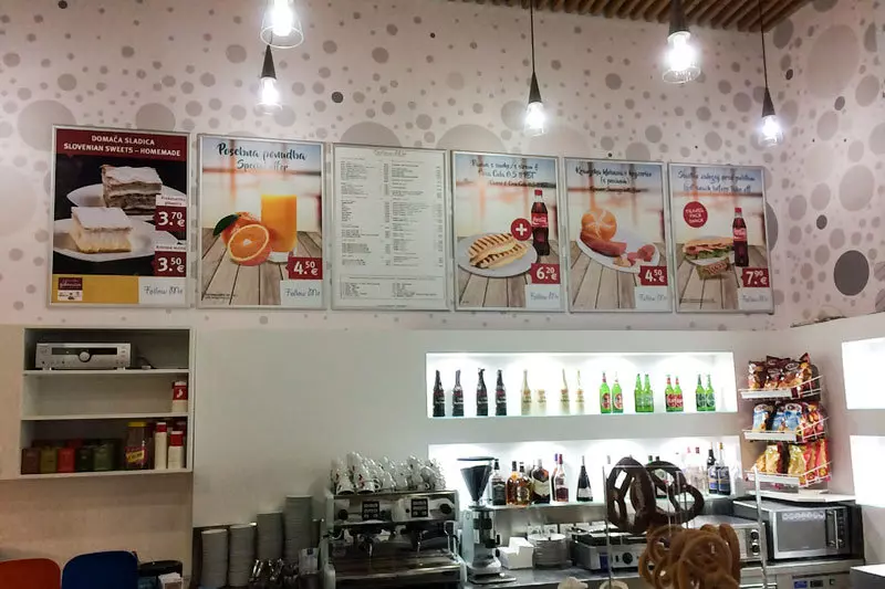 Notranji stenski meniji in promocijski plakati s ponudbo hrane in pijače v lokalu.